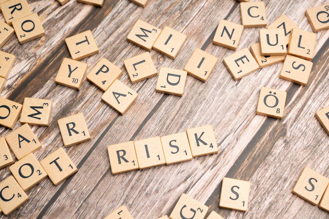 Scrabble tiles on wood spelling the word RISK