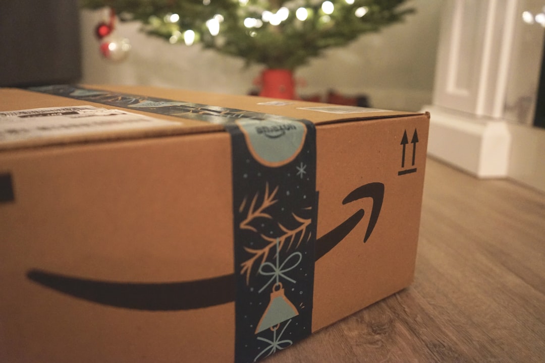 Amazon delivery box with festive tape beside a Christmas tree