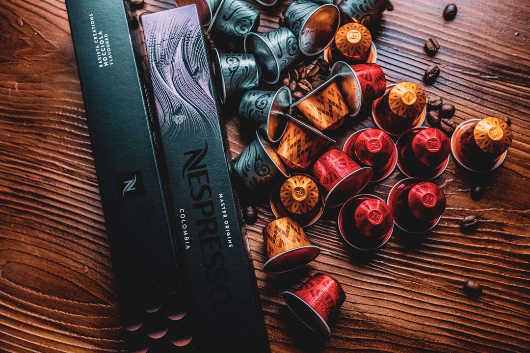Nespresso box with coffee capsules spilled on a wooden table