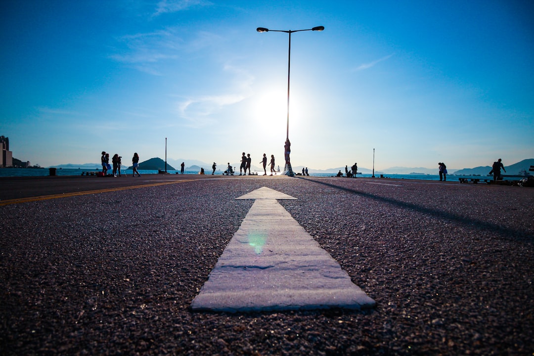 White arrow painted on a road pointing toward the horizon
